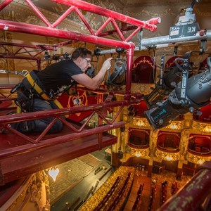 A member of the technical team on the light rig fixing a light at the King's Theatre